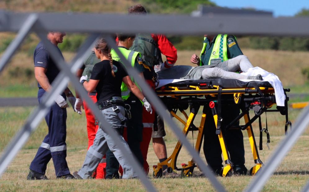 Emergency services attend to a person injured in the eruption, after arriving at the Whakatane Airfield.