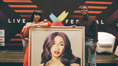 Award-winning rapper, Cardi B, receives painting from Nigerian artist during her visit to the West African country. Photo by Faje Kashope
