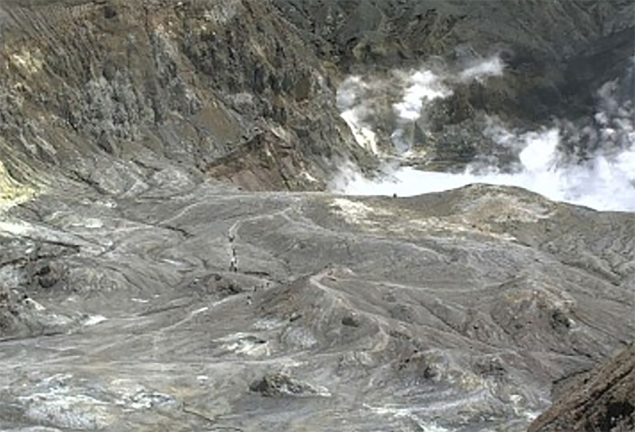 In this image released by GeoNet, tourists can be seen on a trail near the volcano's crater Monday, Dec. 9, 2019, on White Island, New Zealand.