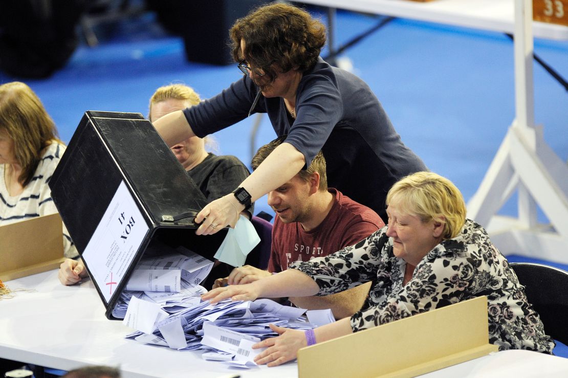 Staff members empty a ballot box at a counting centre in Glasgow, Scotland on June 8,  2017. 