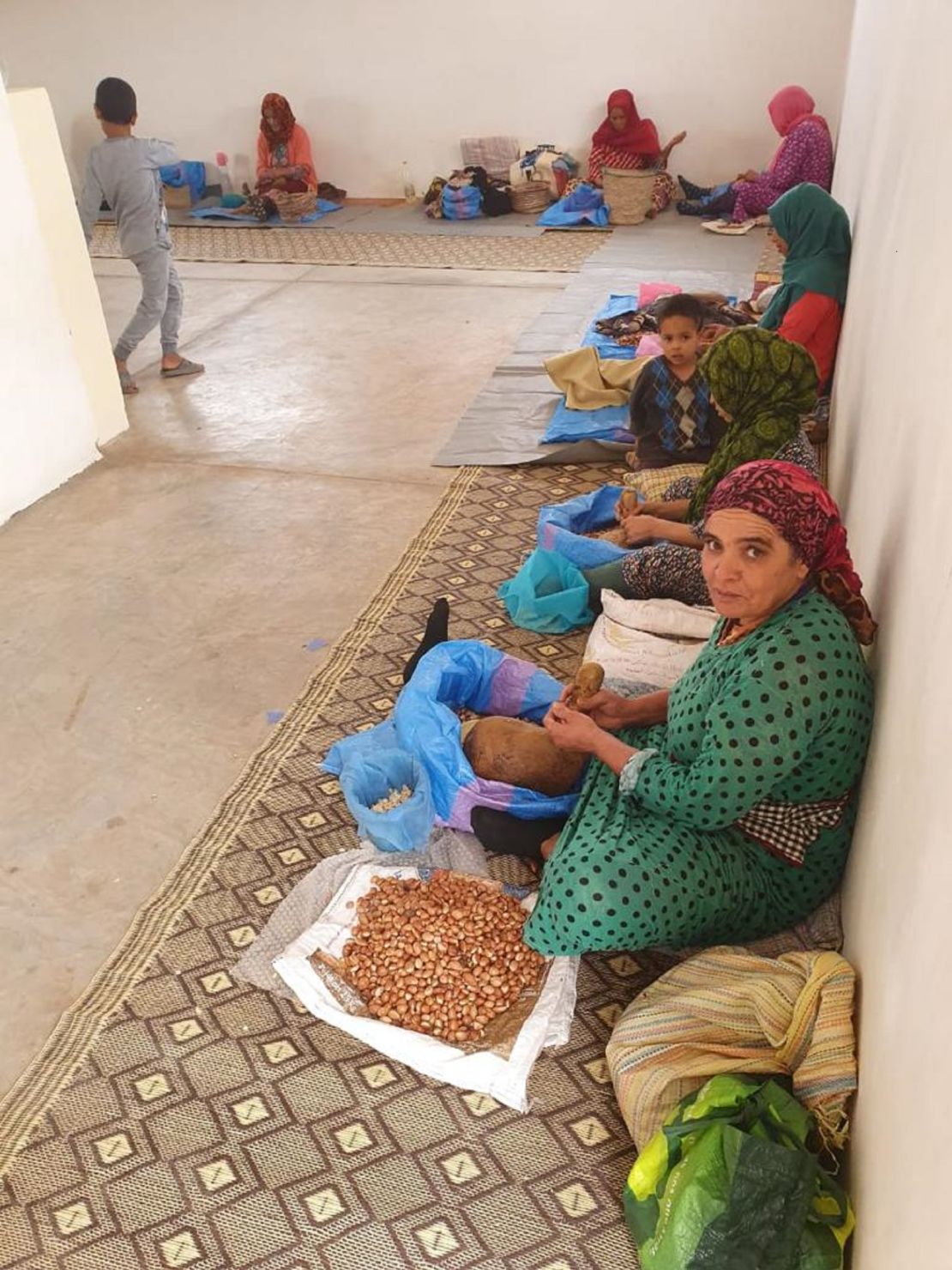 A woman crushing argan oil from the argan tree kernel using traditional methods at the  workshop.
