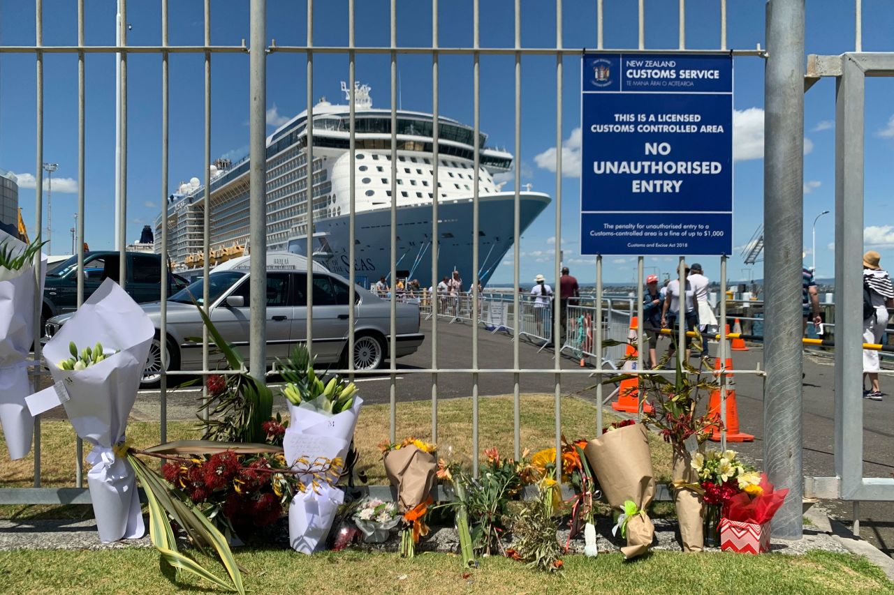 Flowers are laid at a makeshift memorial seen in front of cruise ship Ovation of the Seas, in Tauranga, New Zealand, Tuesday, December 10, 2019.