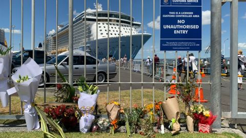 Flowers are laid at a makeshift memorial seen in front of cruise ship Ovation of the Seas, in Tauranga, New Zealand, Tuesday, December 10, 2019. 