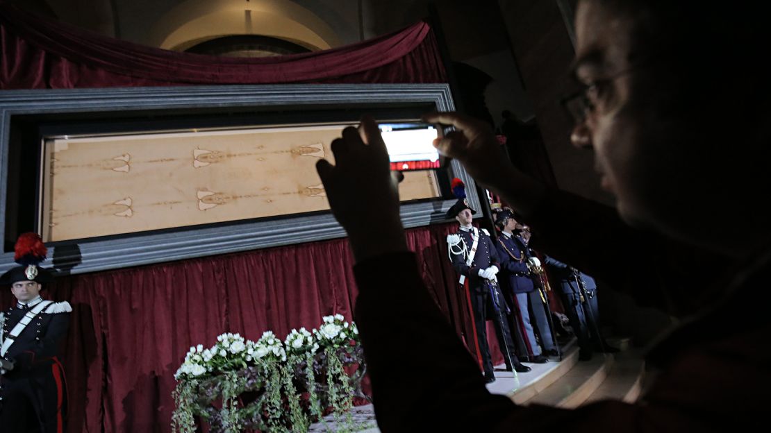 A man takes a photo of the Turin Shroud as it goes on public display in 2015 at the Pope's request