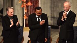 Chair of the Norwegian Nobel Peace Prize comittee Berit Reiss-Andersen (L) and Vice Chair of the Norwegian Nobel Peace Prize comitee Henrik Syse (R) applaud Ethiopia's Prime Minister and Nobel Peace Prize Laureate Abiy Ahmed Ali (C) during the Nobel Peace Prize ceremony at the city hall in Oslo, Norway on December 10, 2019. - Abiy Ahmed is picking up his Nobel Peace Prize in the Norwegian capital as ethnic violence is on the rise at home, festivities are being kept to the bare minimum and he has refused to speak to the media cancelling this years Nobel Peace Prize press conference. (Photo by Fredrik VARFJELL / AFP) (Photo by FREDRIK VARFJELL/AFP via Getty Images)