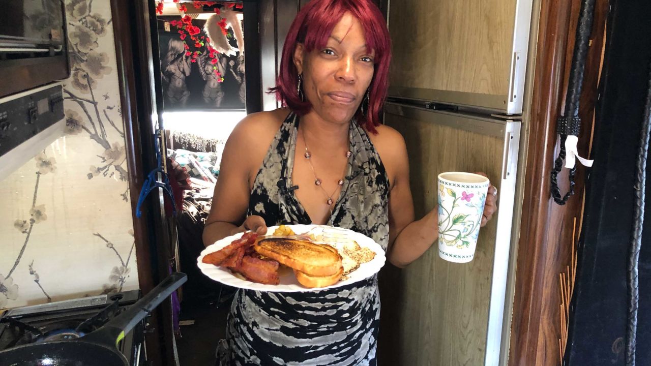 Sharhonda Beavers enjoys a meal in RV, which she opened to a friend she met on the streets.