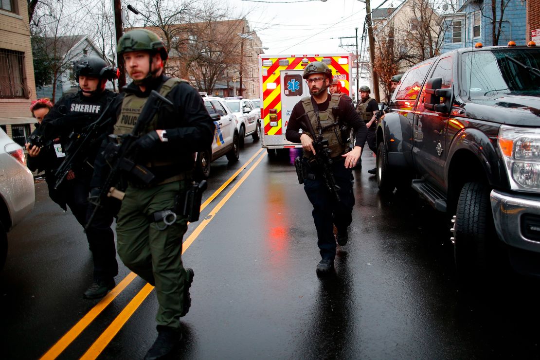 Police officers arrive at the scene following reports of gunfire Tuesday in Jersey City.