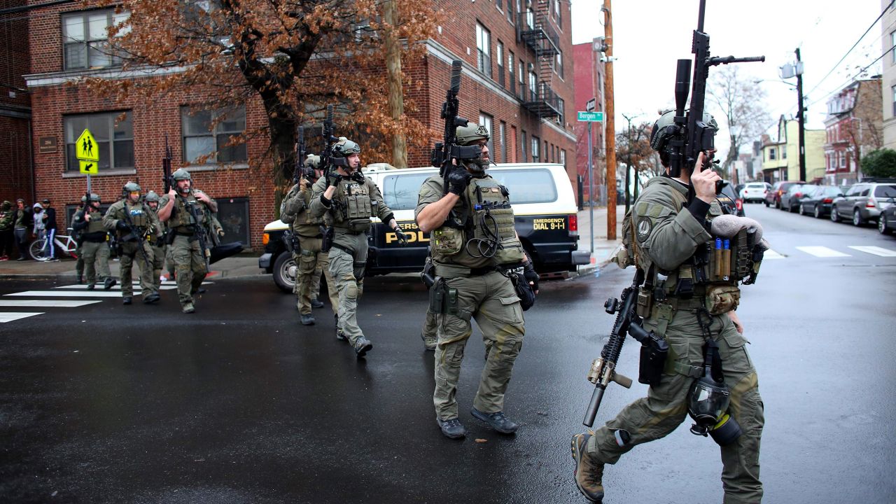 Police officers rush to the scene of an active shooting in Jersey City, New Jersey, on Tuesday.
