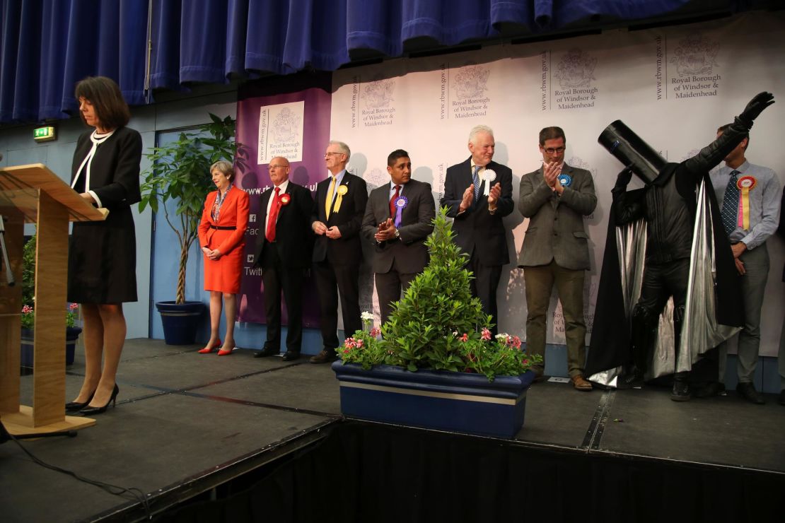 Theresa May (left) and Lord Buckethead (second from right, with the bucket on his head) hear the results in their constituency in 2017.