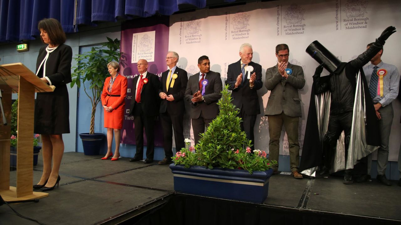 Theresa May (left) and Lord Buckethead (second from right, with the bucket on his head) hear the results in their constituency in 2017.