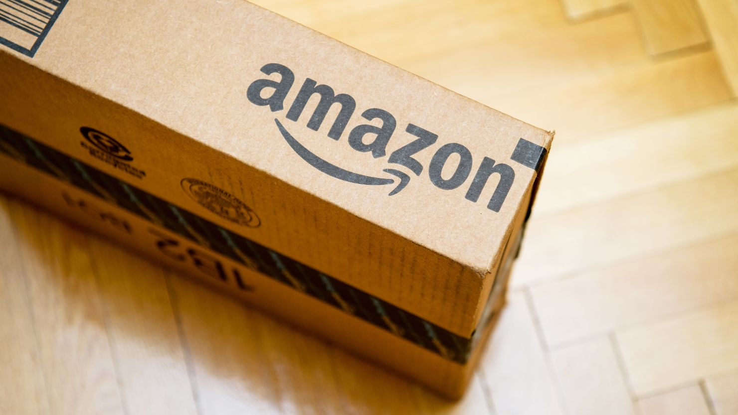 A photo of an Amazon box on a wood floor