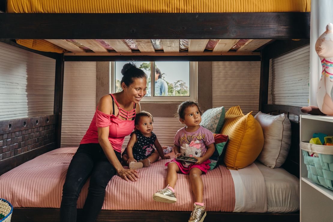 A family sits inside one of the two newly constructed 3D-printed homes in Mexico.