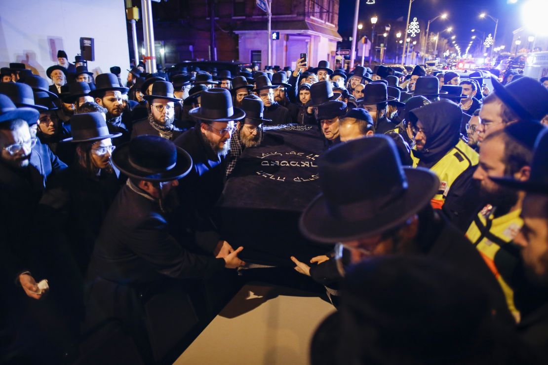 Orthodox Jewish men carry the casket of one of the victims of Tuesday's shootings in Jersey City. 