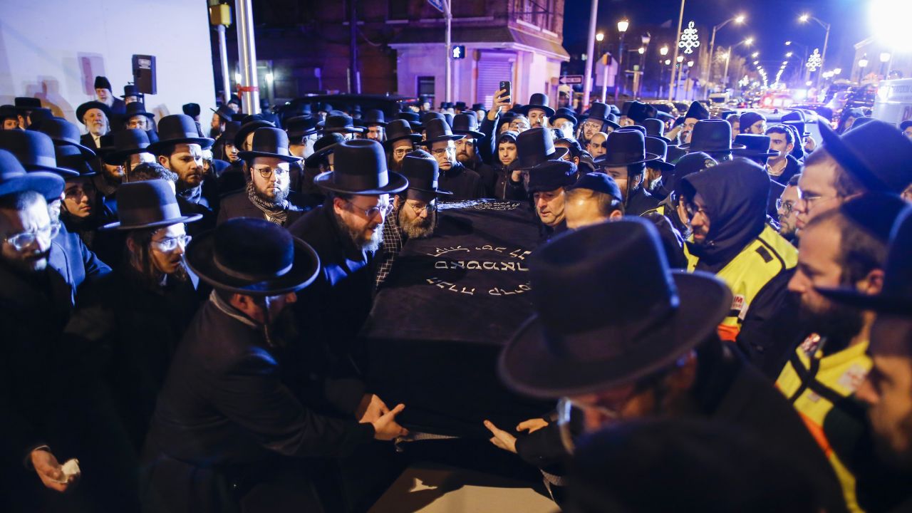 Orthodox Jewish men carry the casket of one of the victims of Tuesday's shootings in Jersey City. 