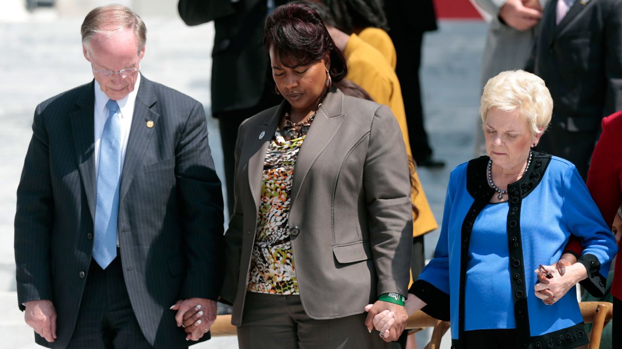 Governor Robert Bentley,  Bernice King and Peggy Wallace Kennedy hold hands during a prayer at the steps of the Alabama State Capitol in March 2015 to mark the 50th anniversary of the 1965 Selma-to-Montgomery voting rights march.