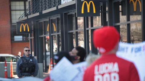 A police officer keeps watch as demonstrators march in front of the McDonalds Headquarters demanding a minimum wage of $15-per-hour and union representation on April 03, 2019 in Chicago, Illinois. 