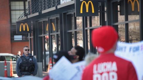 A police officer keeps watch as demonstrators march in front of the McDonalds Headquarters demanding a minimum wage of $15-per-hour and union representation on April 03, 2019 in Chicago, Illinois.