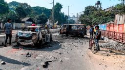 People walk past the remains of gutted vehicles on a road in Guwahati on December 13, 2019, a day after protests against the government's Citizenship Amendment Bill (CAB) broke out across India's northeastern state of Assam. - Internet access has been cut in India's northeastern city of Guwahati after violent protests over a new citizenship law saw two demonstrators shot dead by police, authorities said on December 13. (Photo by Sajjad  HUSSAIN / AFP) (Photo by SAJJAD  HUSSAIN/AFP via Getty Images)