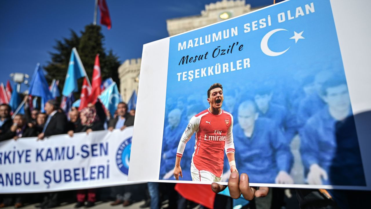 A supporter of China's Muslim Uyghur minority holds a placard of Arsenal's Turkish origin German midfielder Mesut Ozil reading "Thanks for being our voice" past flags of East Turkestan during a demonstration at Beyazid square in Istanbul on December 14, 2019. - Arsenal's Mesut Ozil, a German footballer of Turkish origin, expressed on December 14, 2019 support for Uyghurs in Xinjiang and criticised Muslim countries for their failure to speak up for them. (Photo by Ozan KOSE / AFP) (Photo by OZAN KOSE/AFP via Getty Images)