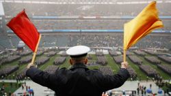 A Navy Midshipman signals his classmate on the field ahead of an NCAA college football game between the Army and the Navy, Saturday, Dec. 14, 2019, in Philadelphia.