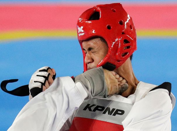 Philippines' Kristopher Uy lands a kick on the head of Cambodia's Rithy Vann during their men's Taekwondo quarterfinals match at the Southeast Asian Games in Manila, Philippines, on Sunday, December 8. Uy won the match.<br />