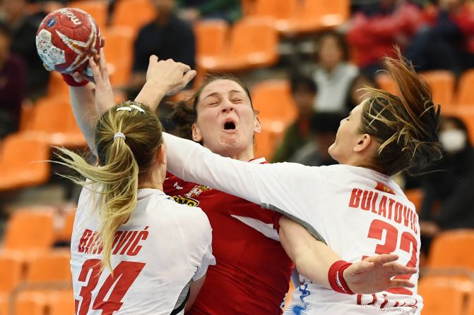 Serbia's Sladana Pop-Lazic, center, fights for the ball with Montenegro's Tatjana Brmovic and Katarina Bulatovic during the Women's Handball World Championship in Kumamoto on Friday, December 13.<br />