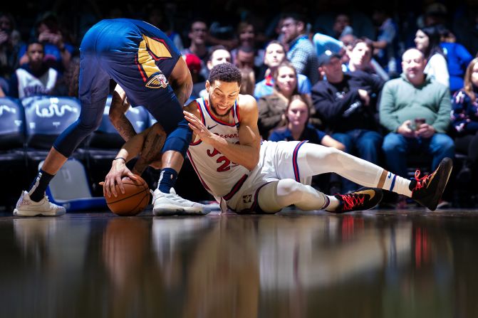 Philadelphia 76ers' Ben Simmons and New Orleans Pelicans' Brandon Ingram battle for a loose ball during a game in Philadelphia on Friday, December 13. 