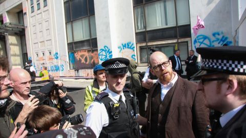 Police arresting Simon Bramwell for super gluing himself to the Shell Centre in London in April.