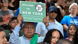 In this June 17, 2019 file photo, a protester holds a sign as members of the state Assembly speak in favor of legislation of the Green Light Bill, granting undocumented immigrant driver's licenses during a rally at the state Capitol, in Albany, N.Y. The bill passed making New York the 13th state to authorize licenses for drivers without legal immigration status.