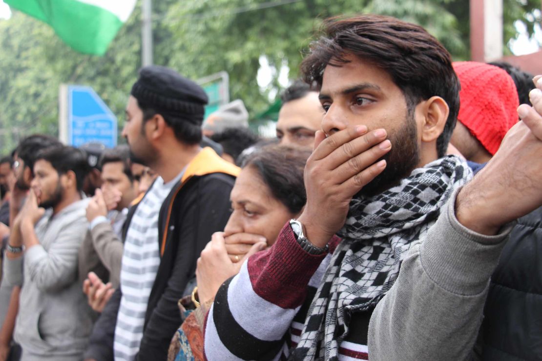 Protesters gather outside Jamia Milia Islamia University in India on Monday, covering their mouths to signify the loss of free speech in the country. 