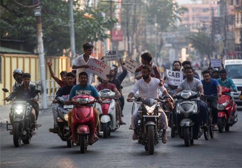 Protesters on motorbikes hold placards during a protest against the bill in Guwahati on Tuesday, December 10.