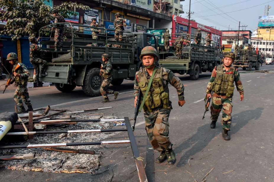 Indian soldiers patrol near a burnt vehicle during a curfew in Guwahati on December 12.