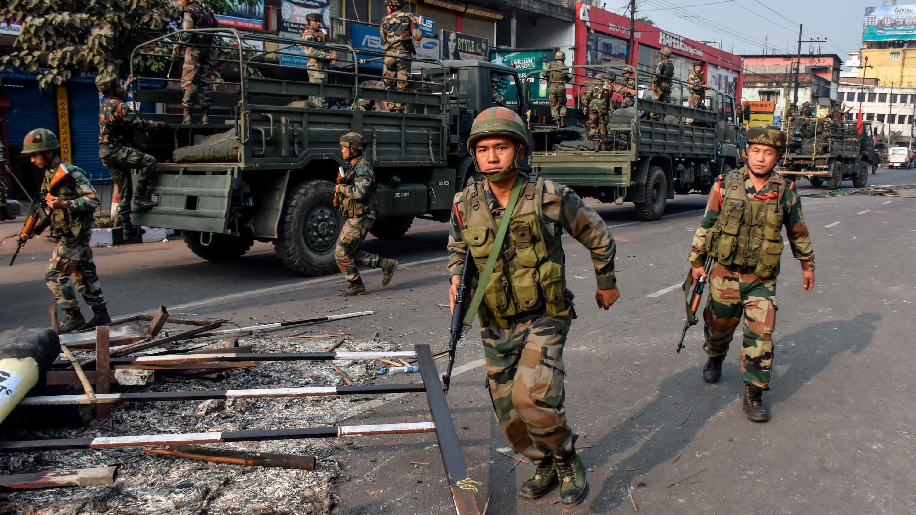 Indian soldiers patrol near a burnt vehicle during a curfew in Guwahati on December 12.