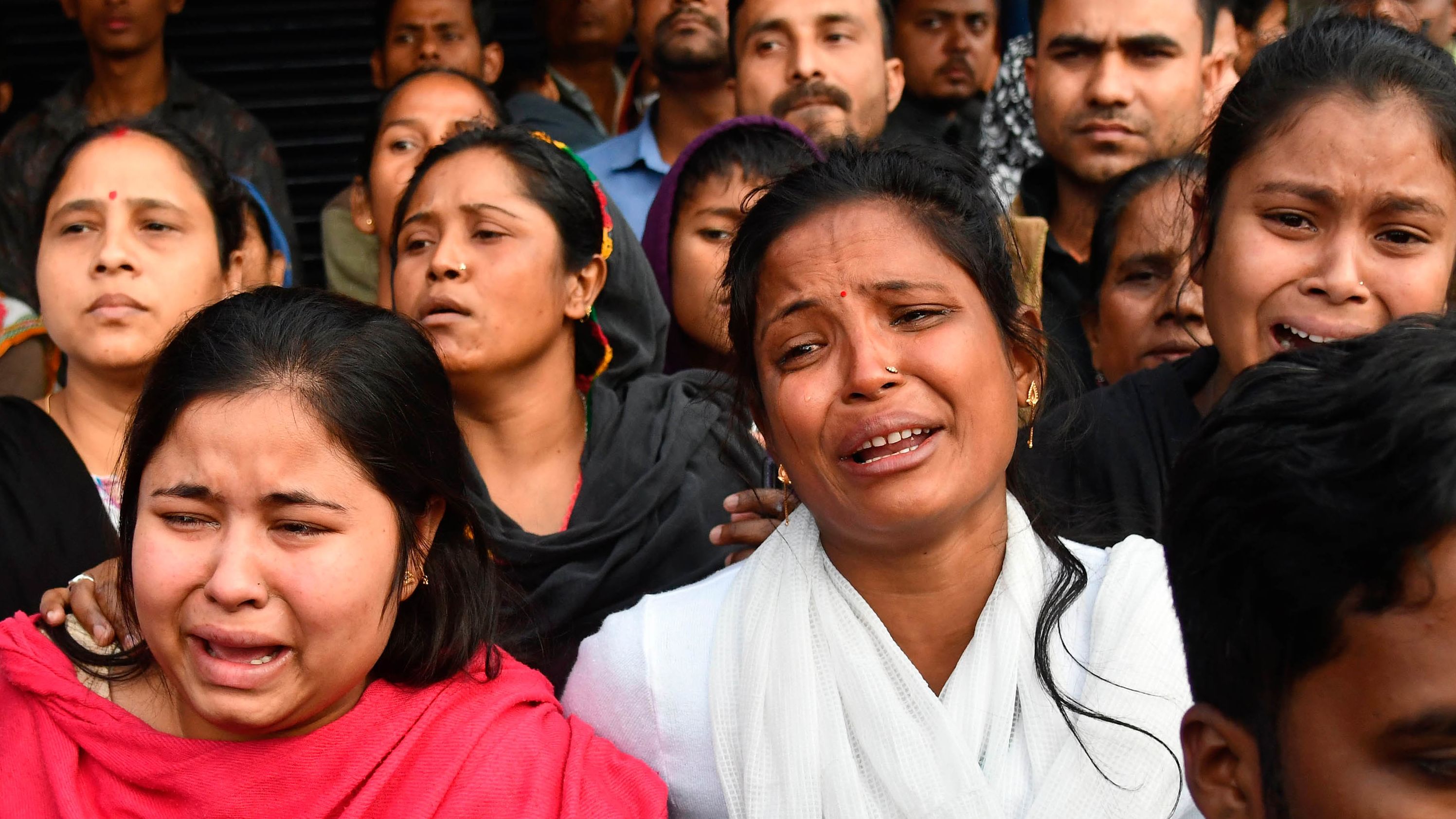 Relatives of Sam Stafford, 18, who was killed during clashes with police the previous day, react in Guwahati on December 13.