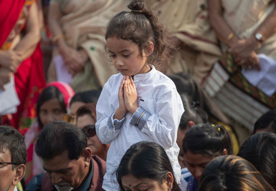 A child prays during a condolence event in Guwahati, India, for demonstrators killed in anti-CAB protests.