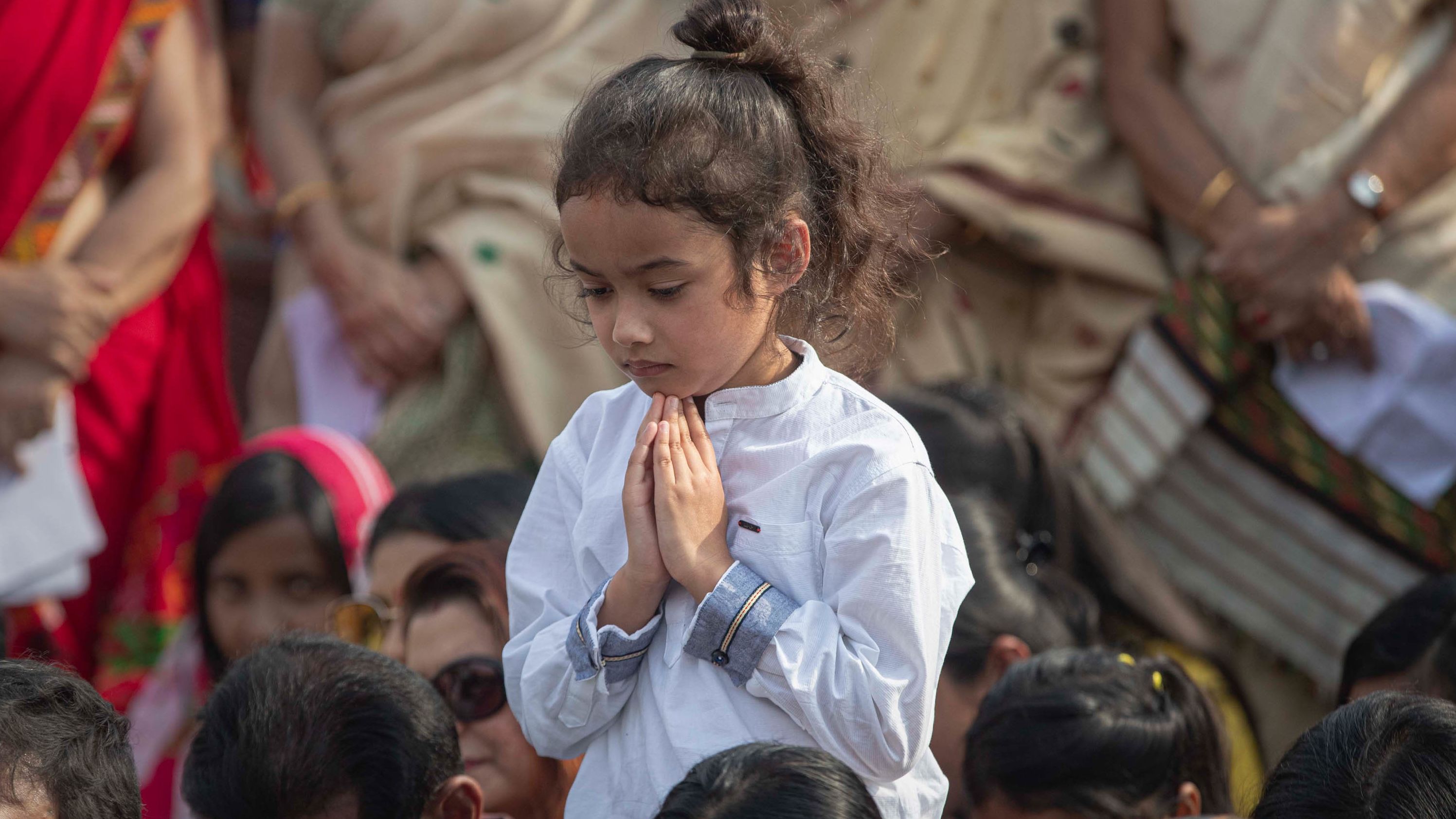 A child prays during a condolence event in Guwahati, India, for demonstrators killed in anti-CAB protests.