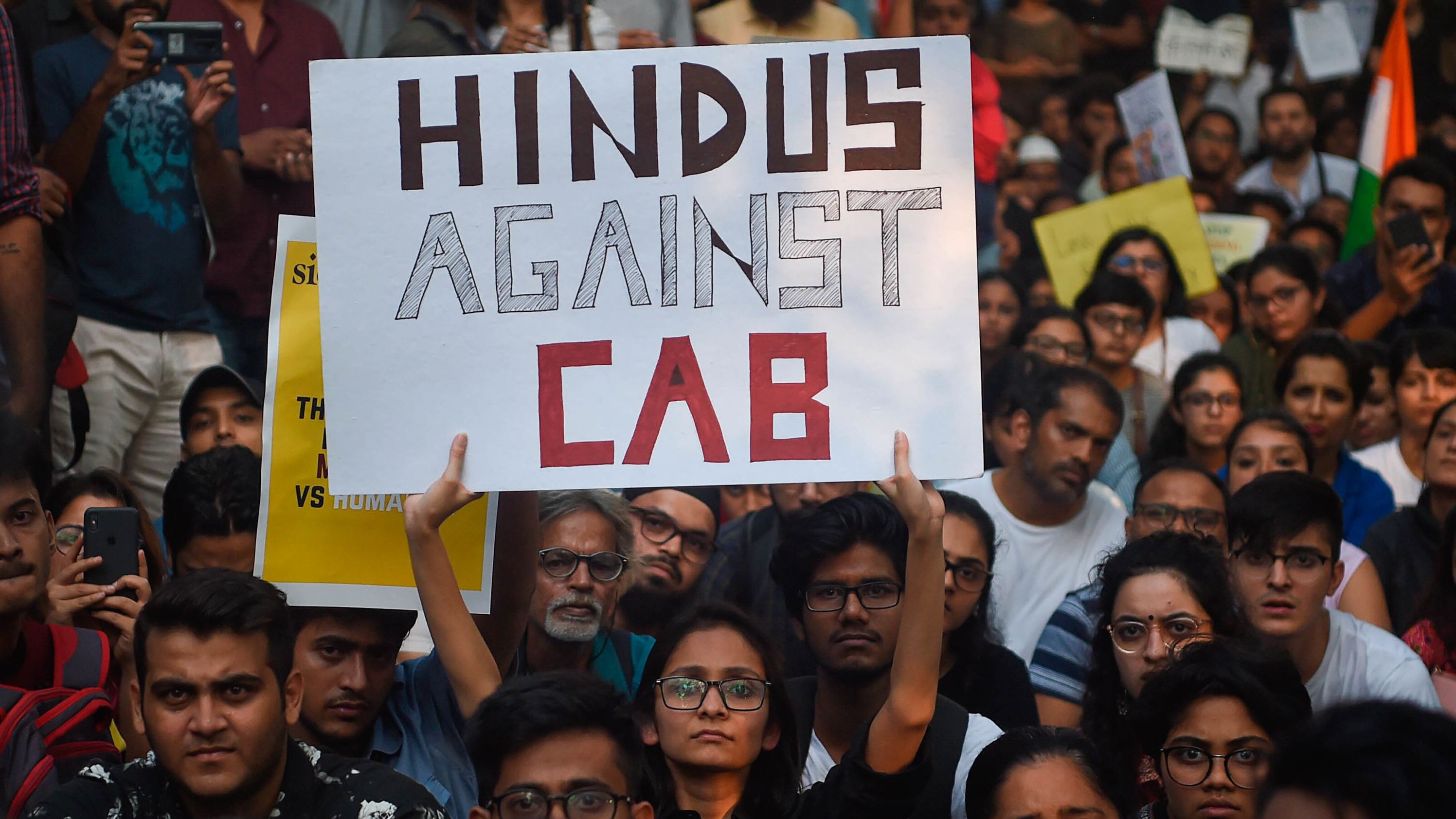 Demonstrators hold signs at the University of Mumbai.