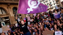 A woman waves a feminist flag as student protesters shout slogans during a demonstration marking International Women's Day in Barcelona on March 8, 2019. - Unions, feminist associations and left-wing parties have called for a work stoppage for two hours on March 8, hoping to recreate the strike and mass protests seen nationwide to mark the same day in 2018. (Photo by Pau Barrena / AFP)        (Photo credit should read PAU BARRENA/AFP via Getty Images)