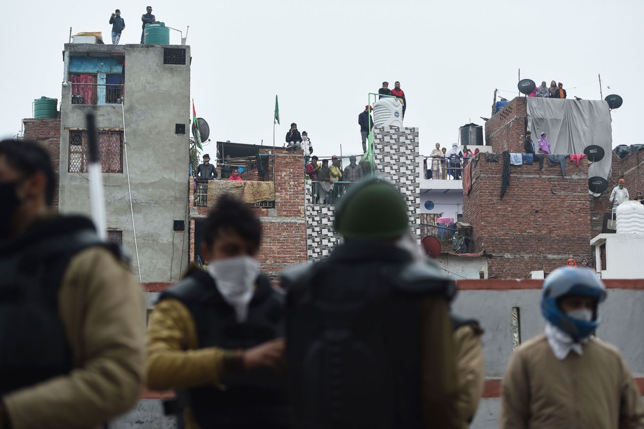 People standing on roofs in New Delhi watch police gathered next to a demonstration on December 17.