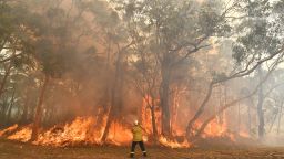 TOPSHOT - This photo taken on December 10, 2019 shows a firefighter conducting back-burning measures to secure residential areas from encroaching bushfires in the Central Coast, some 90-110 kilometres north of Sydney. - Toxic haze blanketed Sydney on December 10 triggering a chorus of smoke alarms to ring across the city and forcing school children inside, as "severe" weather conditions fuelled deadly bush blazes along Australia's east coast. (Photo by SAEED KHAN / AFP) (Photo by SAEED KHAN/AFP via Getty Images)