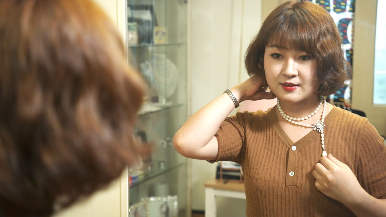 Joo Yang puts on a pearl necklace she designed in Seoul, South Korea. 