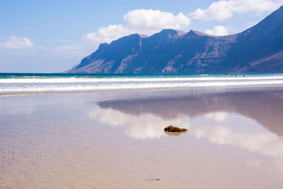 <strong>A perfect beach.</strong> Towering cliffs wrapping Lanzarote's Famara beach were once the rim of a massive volcanic caldera. 