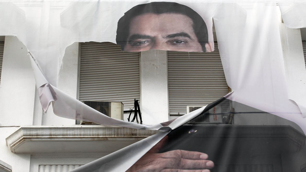 A torn banner of former Tunisian President Zine El Abidine Ben Ali in the center of Tunis in January 2011.
