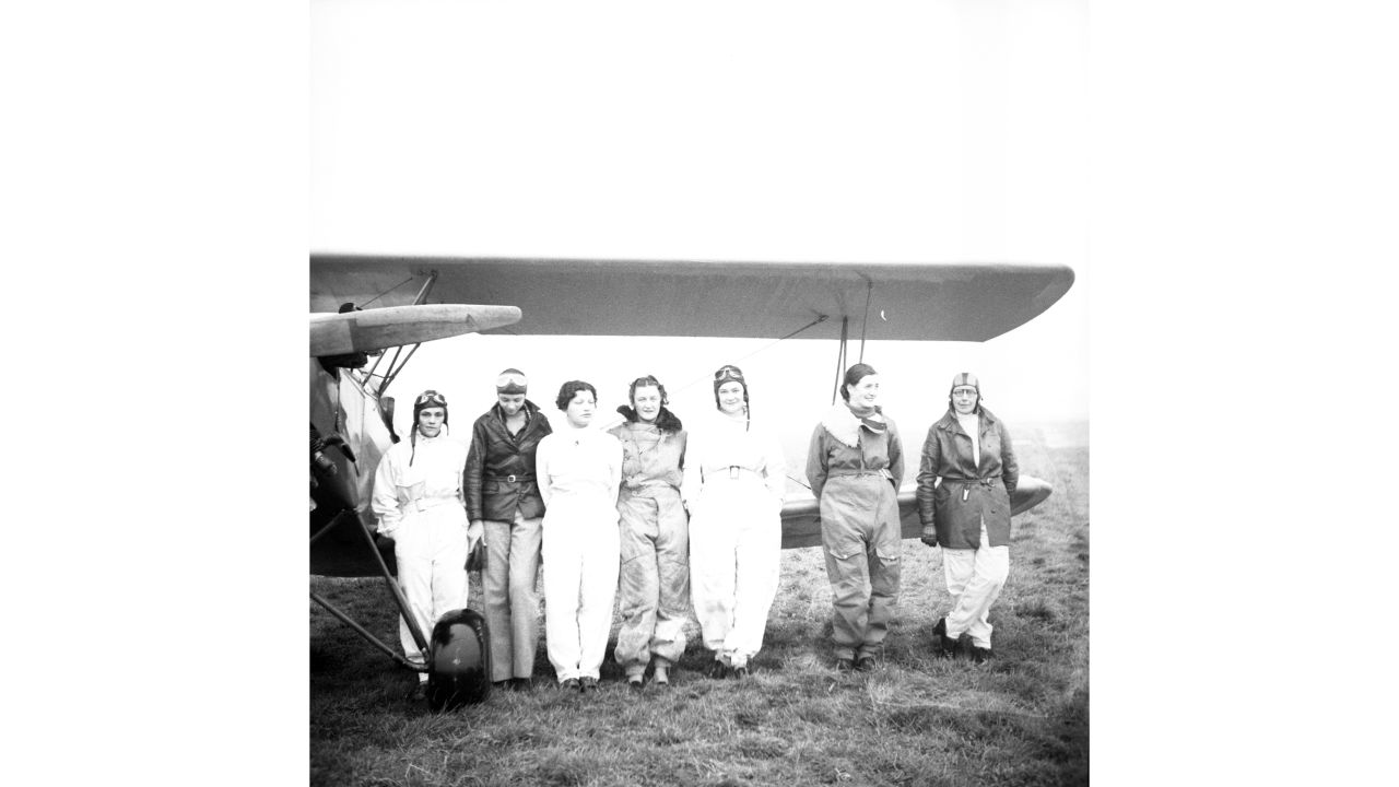 Original members of the Flying Seven Women's Flying Club the Flying Seven pose in front of a biplane in 1936. Gregory's interested in shared personality traits of female aviators such as these.