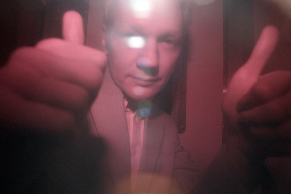WikiLeaks founder Julian Assange reacts behind the heavily tinted window of a police van as he arrives at Wandsworth Prison in London, in 2010.