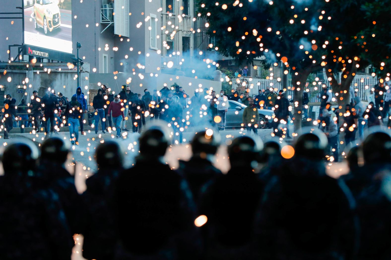 Supporters of Lebanon's Shiite Hezbollah and Amal groups throw fireworks towards Lebanese riot police during clashes on December 14 in Beirut.