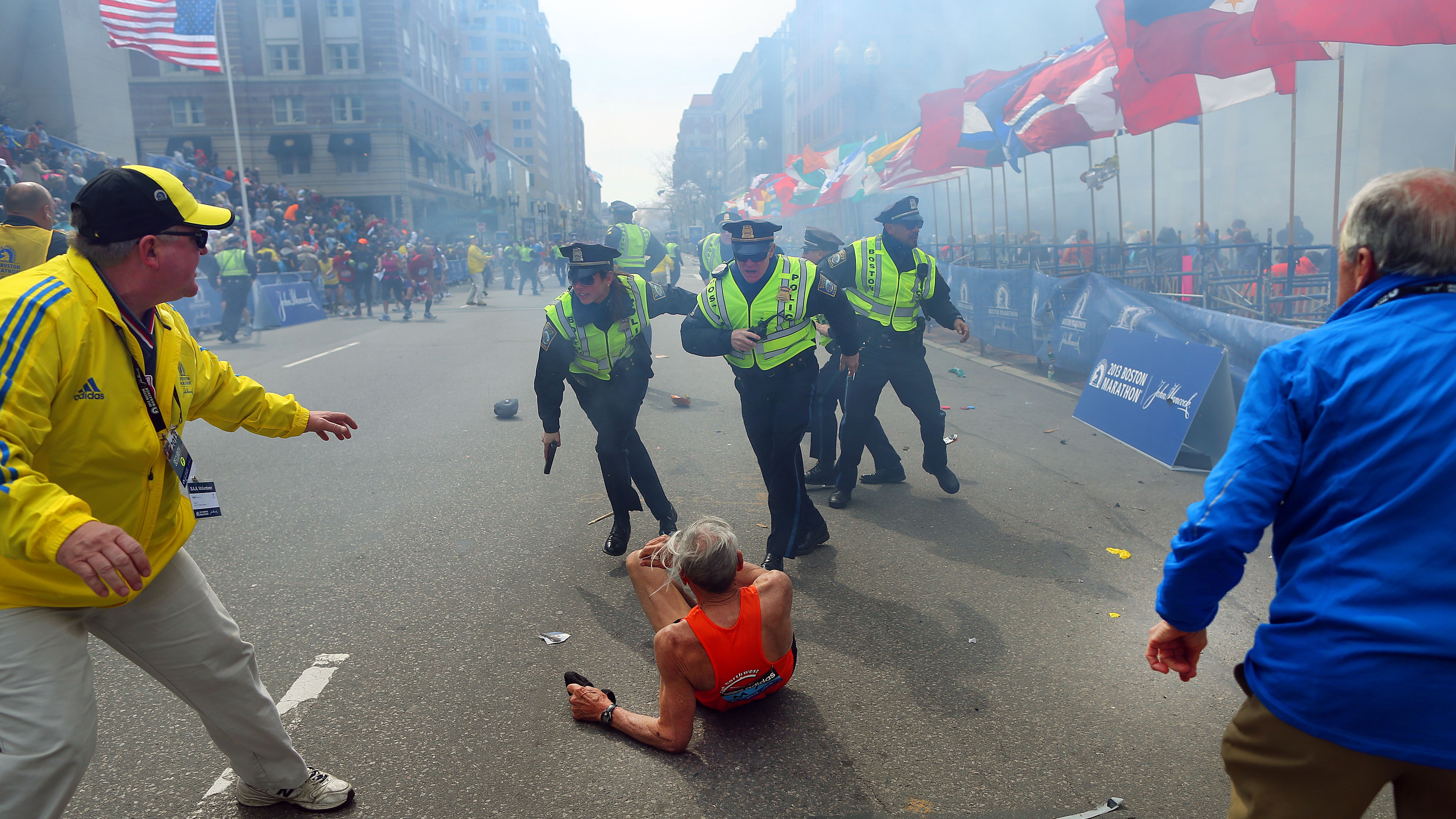 Police officers stand over marathon runner Bill Iffrig as a second explosion sounds near the finish line of the Boston Marathon in April 2013. Three people were killed and at least 264 were injured in <a href="https://www.cnn.com/2013/06/03/us/boston-marathon-terror-attack-fast-facts/index.html" target="_blank">the terror attack.</a>