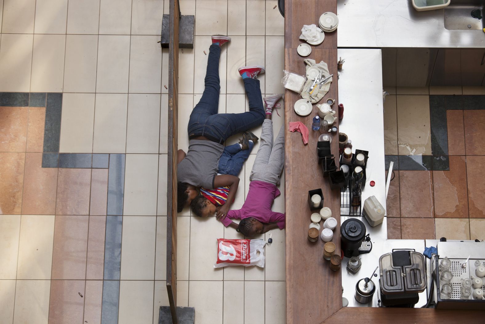 People take cover behind a counter at the Westgate shopping mall after a shootout in Nairobi, Kenya, in September 2013. The Somali terror group Al-Shabaab, an affiliate of al Qaeda, claimed responsibility for <a href="https://www.cnn.com/2013/09/24/world/africa/kenya-mall-attack-timeline/" target="_blank">a bloody four-day siege at the upscale mall.</a> At least 67 people were killed.