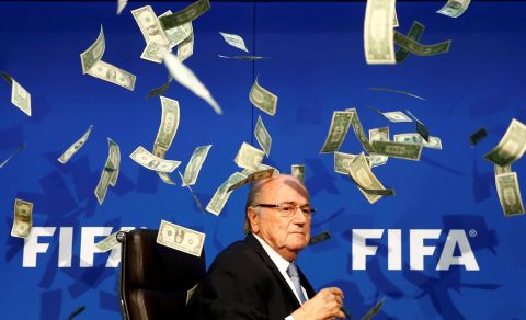 FIFA President Sepp Blatter is showered by dollar bills during a news conference in Zurich, Switzerland, in July 2015. The money was thrown at Blatter by British comedian Simon Brodkin, who was then ushered away from the stage. Blatter had led soccer's governing body since 1998, but he decided to stand down as FIFA battled corruption scandals.