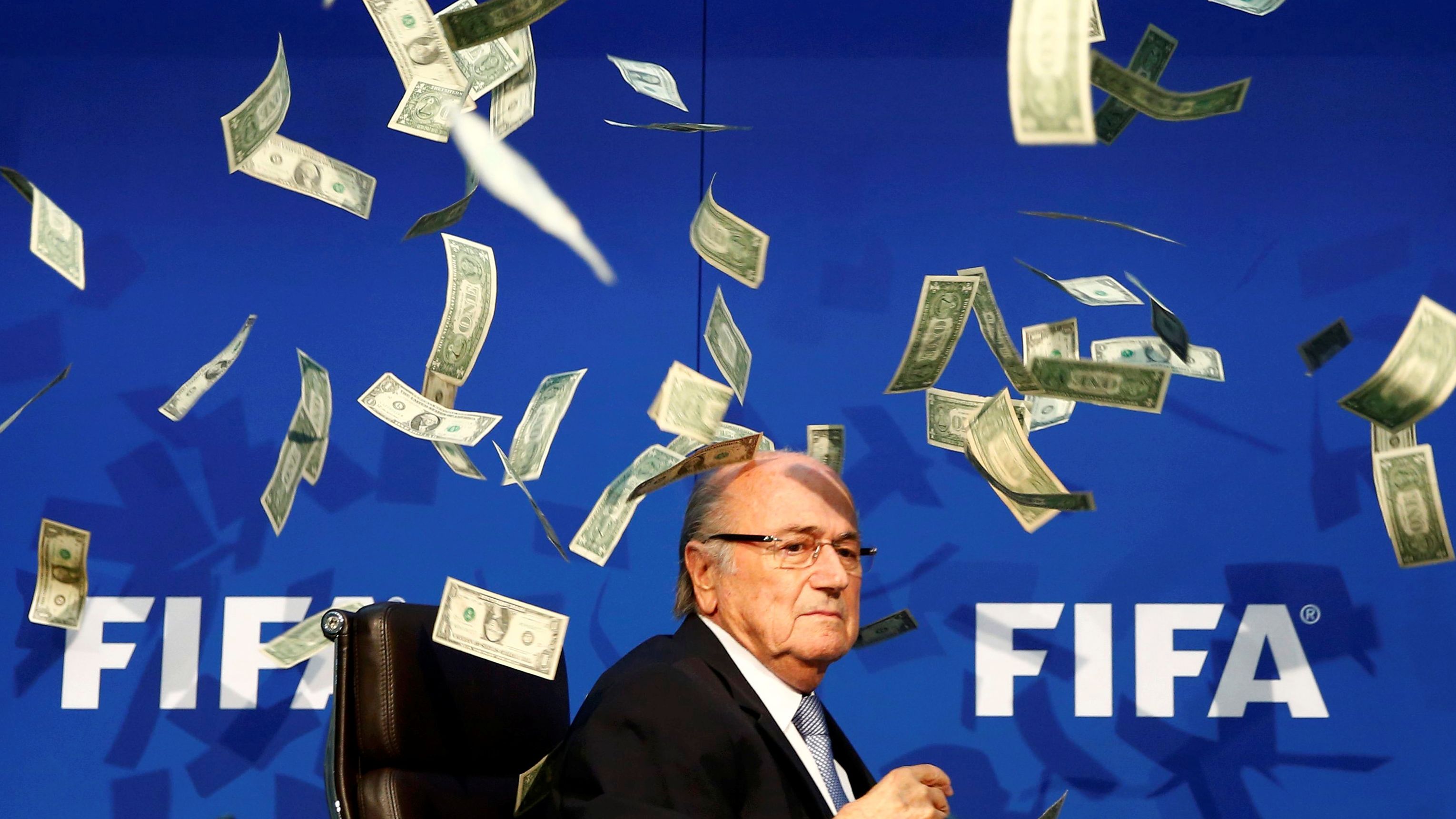 FIFA President Sepp Blatter is showered by dollar bills during a news conference in Zurich, Switzerland, in July 2015. The money was thrown at Blatter by British comedian Simon Brodkin, who was then ushered away from the stage. Blatter had led soccer's governing body since 1998, but he decided to stand down as FIFA battled corruption scandals.
